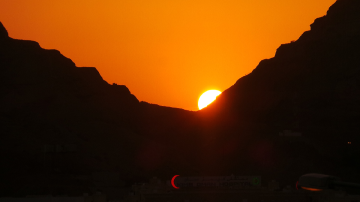 sun is setting down over the moon