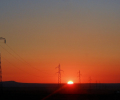 Sunrise with long chain of electric poles